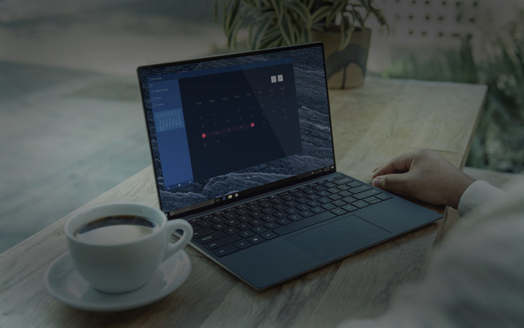 A imagem mostra um notebook acima de uma mesa, tendo ao lado, uma xícara de café, e aparentemente o usuário faz uma gestão remota.